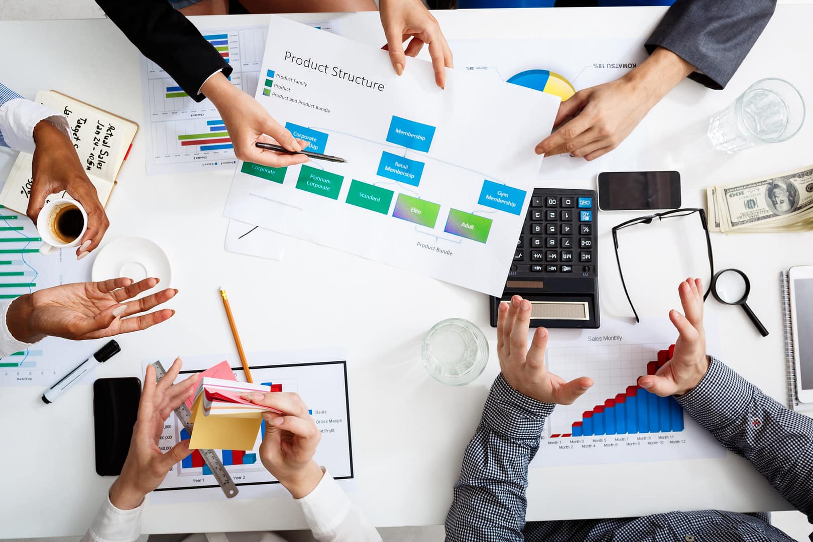 Picture of businessmen's hands on white table with documents and drafts